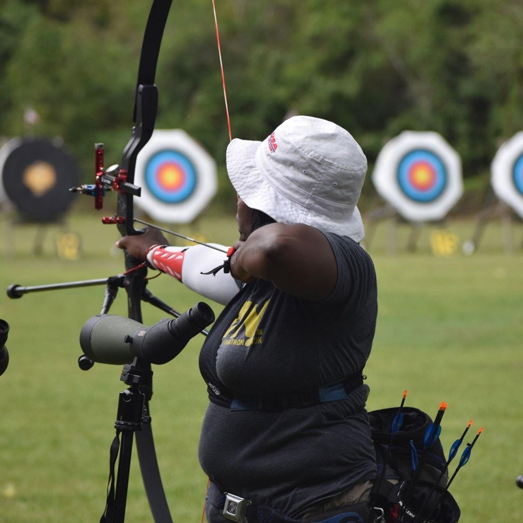 A person shooting a bow at targets outside