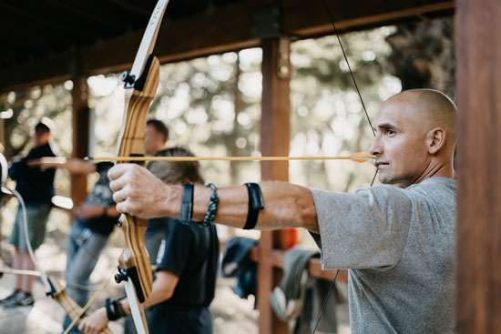 an archer pulls back his bow