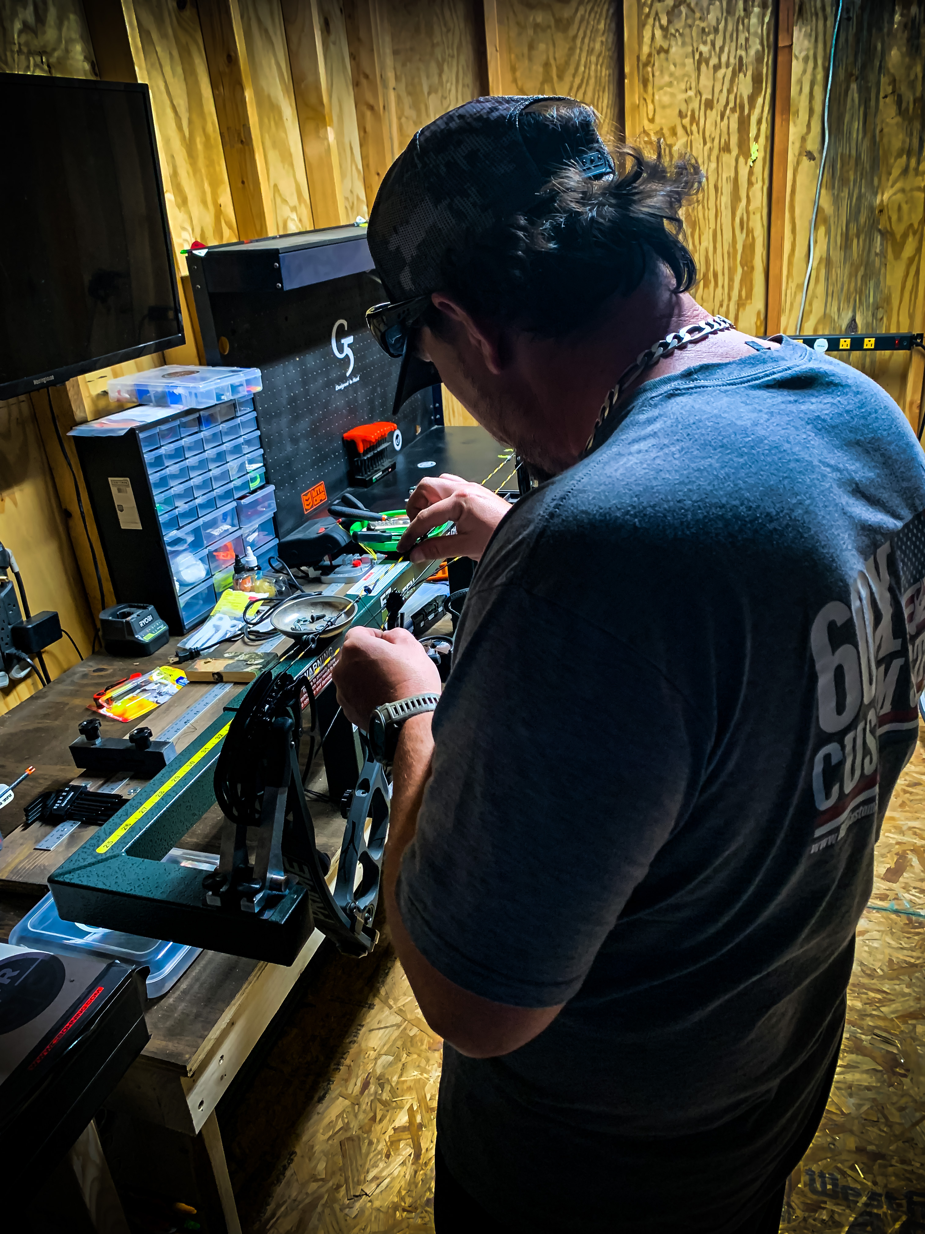 A man working on his bow in his home archery shop