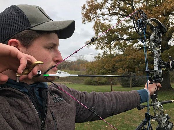 man practicing with a compound bow