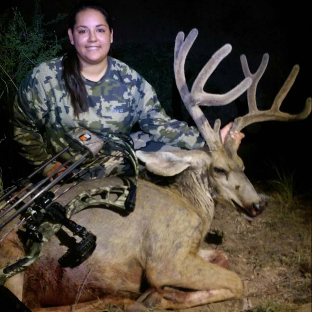 Tiffany with killed monster buck holding his rack